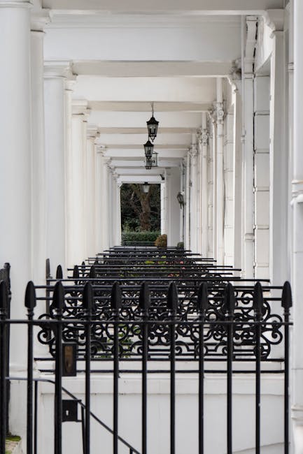 A row of brightly coloured terraced houses in South Kensington with pastel pink, yellow, blue, and purple facades, each featuring white framed sash windows and black iron railings along the pavement. 